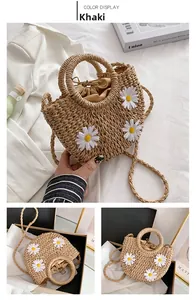 Detail of khaki straw bag featuring white daisy appliques and a drawstring liner
