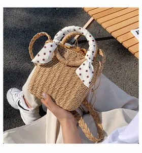 Detailed macro view of handmade woven straw bag with floral scarf handle and drawstring lining