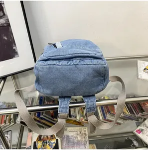 Bovenaanzicht van denim mini-rugzak met verstelbare lichtgrijze stoffen schouderbanden