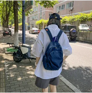 Vista exterior de una mochila de mezclilla azul oscuro vintage con etiqueta naranja y correas anchas