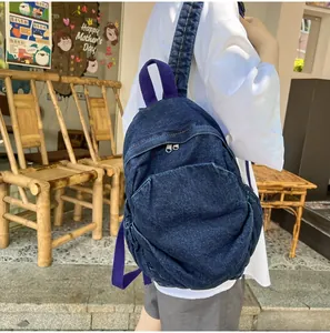 Primer plano de mochila vaquera vintage con tela azul marino y detalles de correa morada