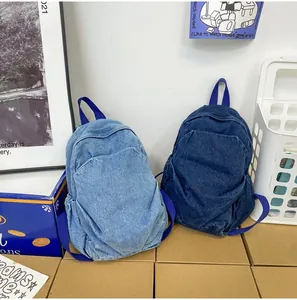 Detalle de mochilas de gran capacidad en denim lavado en tonos azul claro y oscuro