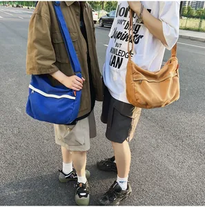 Outdoor-Streetstyle-Ansicht blauer und khakifarbener Canvas-Umhängetaschen mit Riemen