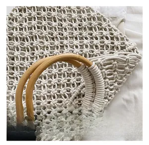 Détail de la poignée ronde en bois sur le sac de plage blanc en macramé tressé