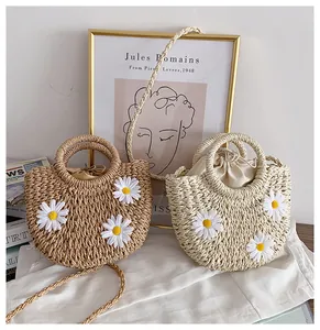 Close-up of woven straw bags with 3D daisy flowers and secure drawstring inner lining