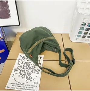 Detailaufnahme der armee-grünen Canvas-Umhängetasche mit verstellbarem Gurt und Reißverschluss