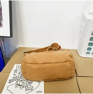Detailansicht des braunen Canvas-Messenger-Bags mit robustem Boden und verstellbarem Gurt