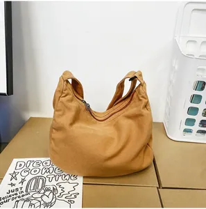 Detailaufnahme der senfgelben Canvas-Umhängetasche mit Metallreißverschluss und breitem Gurt