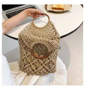Détail du motif en maille tissée à la main et poignées rondes en bois du sac en coton
