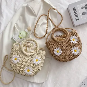 Straw woven crossbody bucket bag with white daisy decor for summer beach vacations