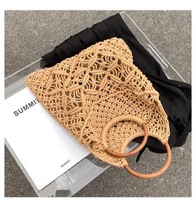 Détail du sac de plage tissé en coton avec motif ajouré et poignées rondes en bois
