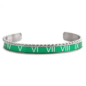 Detail of green enamel cuff bracelet with Roman numeral engravings and gear texture