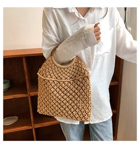 Détail du sac à main tissé en corde de coton avec poignées rondes en bois et motif ajouré