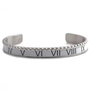 Detailed macro view of silver Roman numeral cuff bracelet with white enamel and serrated edges