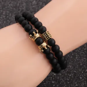 Detail of beaded bracelet set with matte black beads and golden crown accessories