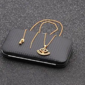 Detail view of gold Evil Eye necklace with vibrant multi-color zircon inlay on black box