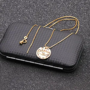 Macro detail of gold-tone Evil Eye coin pendant necklace with colorful gemstones