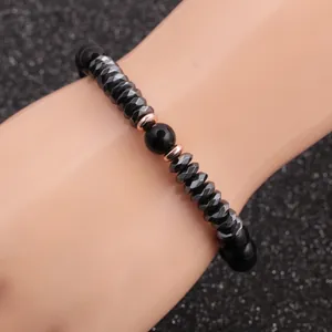 Détail d'un bracelet pour homme en perles noires de 8mm avec accents en or rose