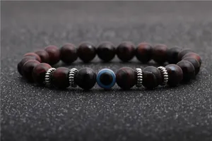 Macro view of 8mm red tiger eye beads with silver spacers and blue evil eye bead detail