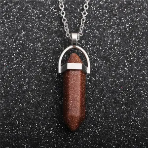 Macro shot of brown goldstone hexagonal point pendant on silver chain necklace