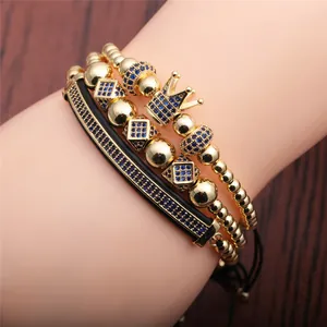 Luxury gold beaded crown bracelet set with blue zircon and black leather straps on wrist