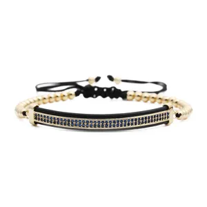 Adjustable gold beaded bracelet with blue zircon inlay on a black curved bar bar