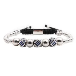 Detail of adjustable silver beaded bracelet with blue zircon crown and rhombic charms