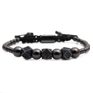 Detail of adjustable black beaded bracelet featuring three blue zircon square charms