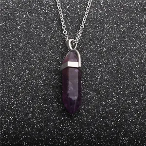 Detail of a purple hexagonal prism crystal pendant on a silver metal chain necklace