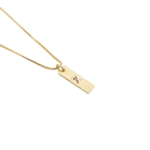 Detail einer goldenen Box-Kette mit rechteckigem Anhänger und farbigen Zirkoniasteinen