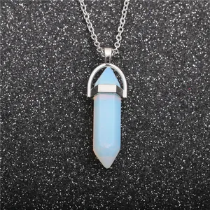 Macro detail of hexagonal opal stone pendant with silver chain on a dark backdrop