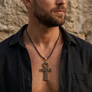 Gros plan du pendentif Ankh doré avec hiéroglyphes égyptiens sur cordon en cuir