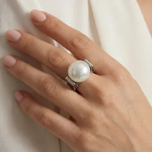 Nahaufnahme eines großen weißen Perlenrings am Modell mit silbernem Ringband