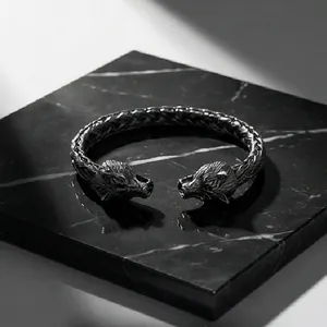 Macro detail of a vintage double wolf head open bangle with oxidized textured finish