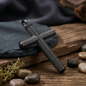 Détail d'un pendentif croix avec texture moletée diamant et finition en acier noir mat