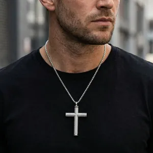 Détail du collier croix en acier inoxydable pour homme avec texture moletée sur mannequin