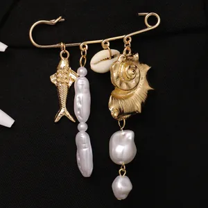 Vue détaillée d'une broche sur le thème de l'océan avec poisson d'or et perles baroques.