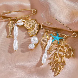 Détails du lot de broches marines dorées avec coquillage et corail sur fond de soie