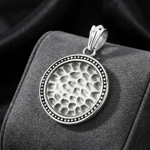 Retro hammered texture round stainless steel pendant necklace for men from a 45-degree angle