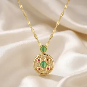 Golden windmill necklace with green opal and red zircon on elegant silk background