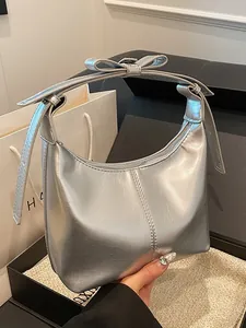 Silver metallic leather croissant bag with a bow accent and minimalist half-moon shape