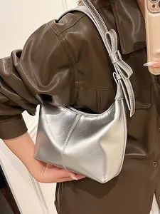 Chic silver metallic crescent shoulder bag for women featuring a stylish bow on strap