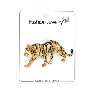 Detailed close-up of tiger brooch with gold and black oil drip patterns on jewelry card