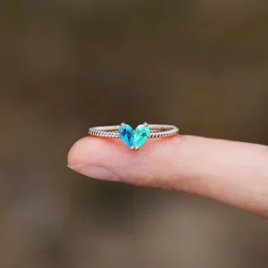 Macro detail of s925 silver ring featuring two pear-shaped birthstones in a heart shape