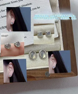 Detailed set of silver stud earrings featuring oval heart and square grey stones