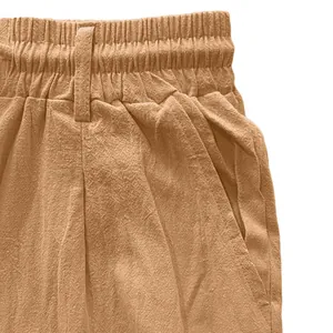 Detail of camel cotton linen pants featuring elastic waistband and side pocket texture