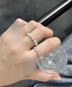 Macro detail of S925 silver lace rings with floral pearl accents on model hand