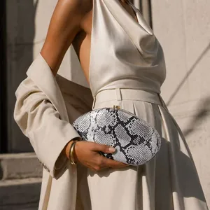 Elegant black and white snake print acrylic evening clutch bag with a golden clasp