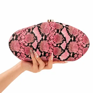 Close-up view of a pink snakeskin pattern acrylic evening clutch bag held by a hand