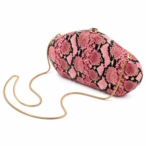 Close-up of pink snakeskin pattern acrylic evening clutch with gold snake chain